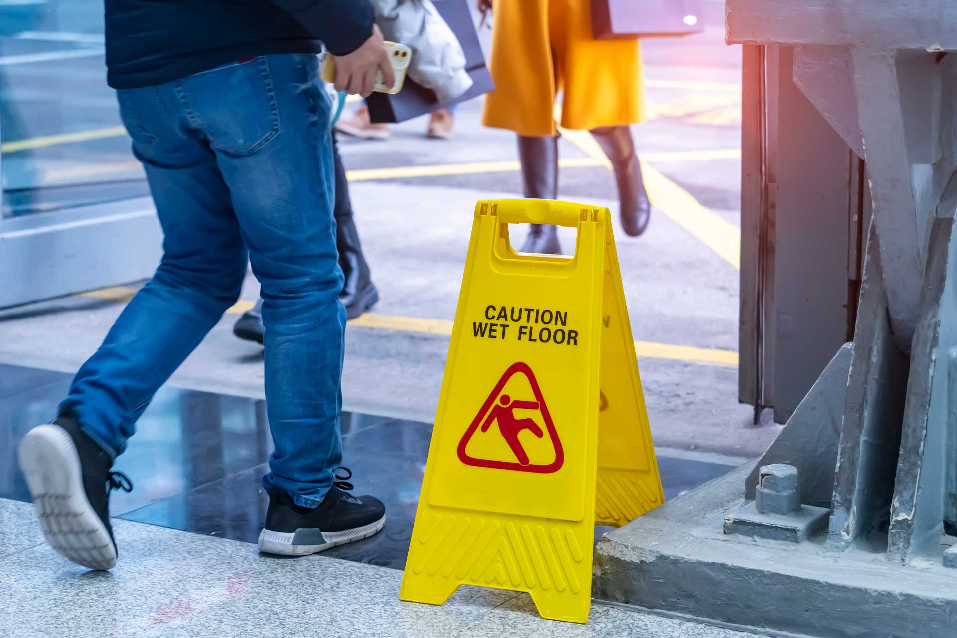 man walking by caution wet floor sign